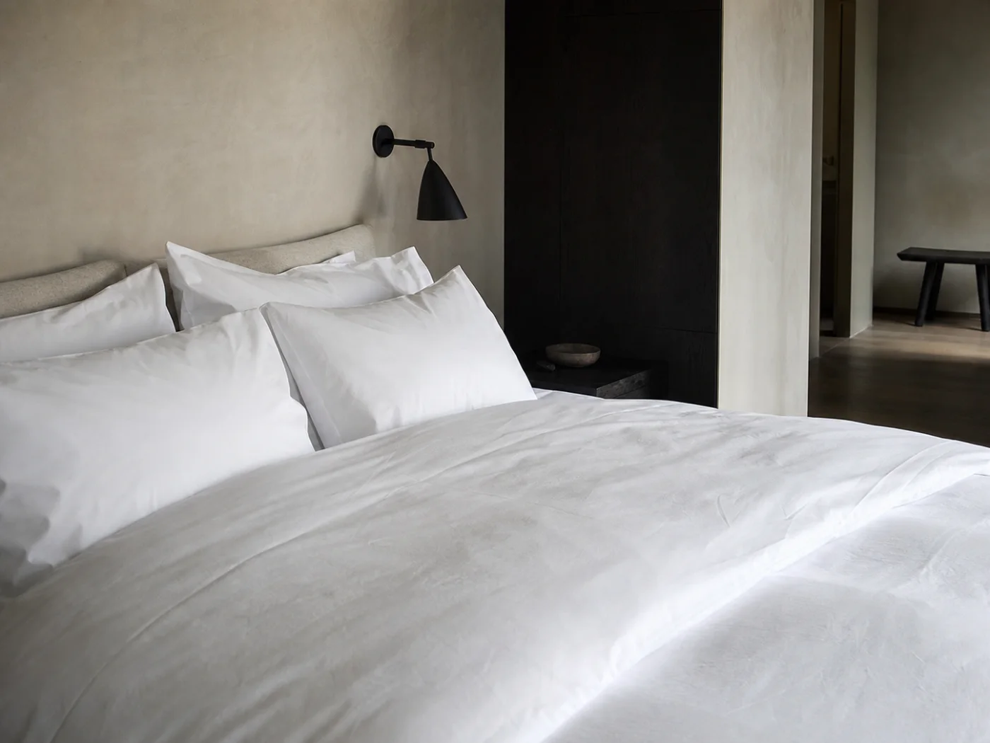 A boutique hotel bed dressed in freshly finished white linen